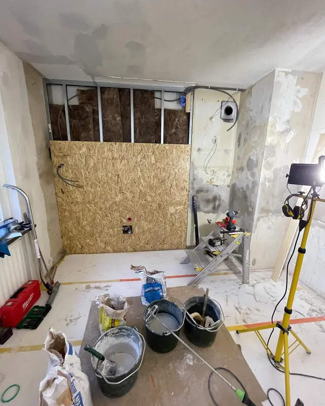 Badrum under renovering med nya väggskivor och pågående tätskiktsarbete