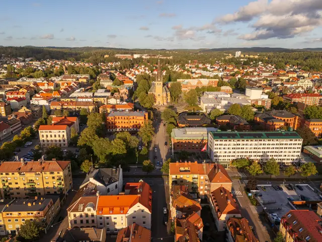 Flygvy över stad med kyrka och tegeltak i kvällsljus