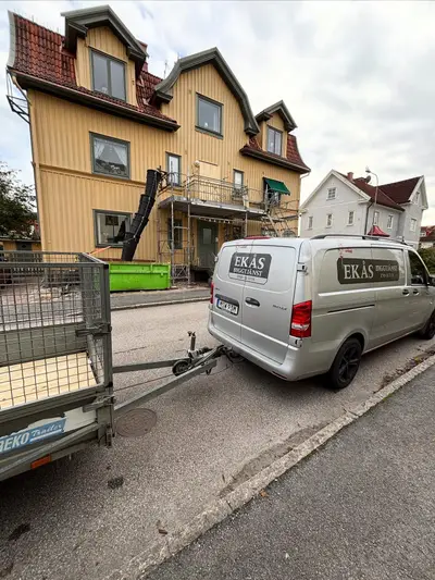 Ekås Byggtjänsts servicebil vid ett gult flerfamiljshus