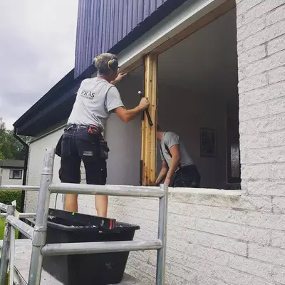 Hantverkare från Ekås byter fönster från ställning