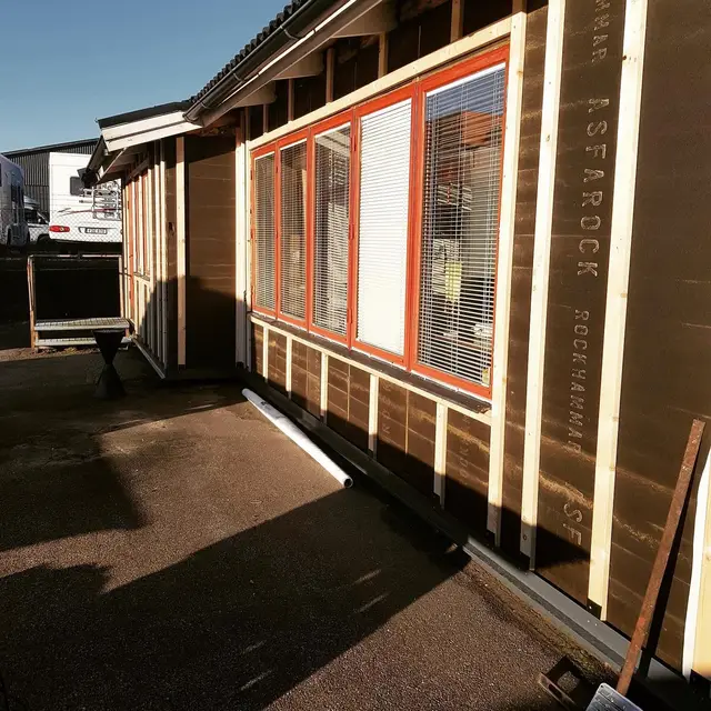 Fasad under renovering med vindskydd och nya fönster