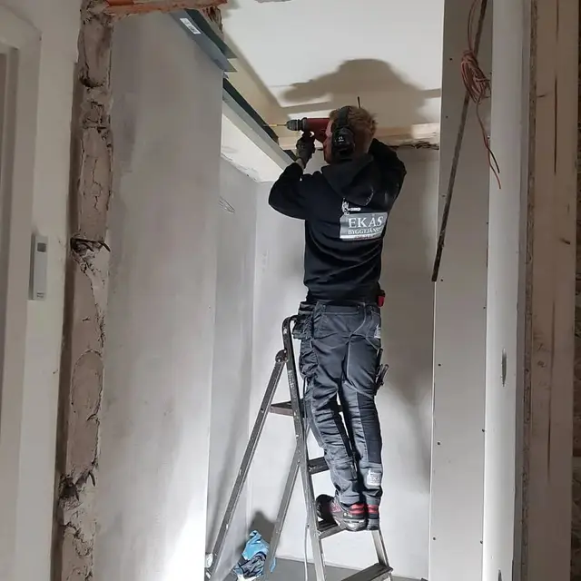 Hantverkare från Ekås Byggtjänst borrar i taket under en renovering