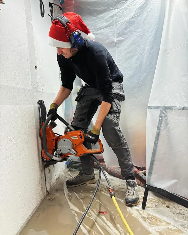Hantverkare sågar i betongvägg under renovering
