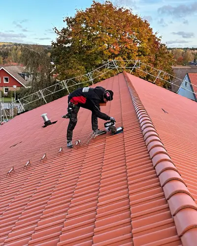 Hantverkare lägger röda takpannor
